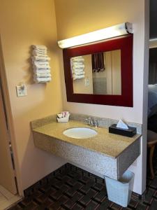 a bathroom with a sink and a mirror at Arbor Inn - Weymouth in Weymouth