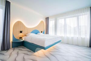 a bedroom with a bed and a large window at prizeotel Dresden-Mitte in Dresden