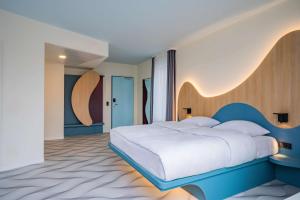 a bedroom with a large white bed and a wooden headboard at prizeotel Dresden-Mitte in Dresden