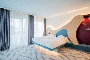 a bedroom with a bed and a large window at Prize by Radisson, Dresden Mitte in Dresden +54 photos