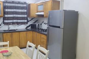 eine Küche mit einem Kühlschrank und einem Tisch mit Stühlen in der Unterkunft Un appart moderne et neuf in Tlemcen