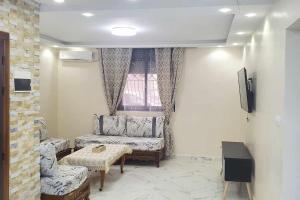 - un salon avec un canapé et une fenêtre dans l'établissement Un appart moderne et neuf, à Tlemcen