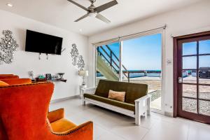 a living room with a couch and a tv at Casa Borgoña 40 - Playa Arcangel in Rosarito
