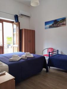 una camera con 2 letti e asciugamani su un letto di Appartamenti Blu Mare a Castellammare del Golfo