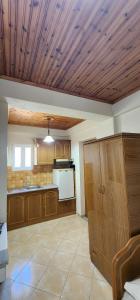 a large kitchen with wooden cabinets and a ceiling at Villa Bianca1 in Piqeras