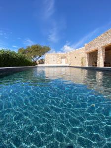 une piscine d'eau en face d'un bâtiment dans l'établissement Kaouki Lodge, à Sidi Kaouki