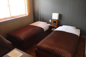 Postel nebo postele na pokoji v ubytování Hotel Saika