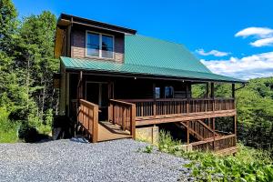 a house with a green roof and a porch at Rocky Top Jewel Cabin in Park Settlement
