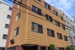 a building with a wooden facade on a street at Hotel Saika in Fujisawa