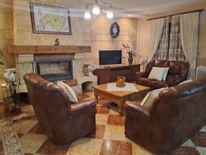 een woonkamer met lederen meubels en een open haard bij Son Pujol in Las Ollerías