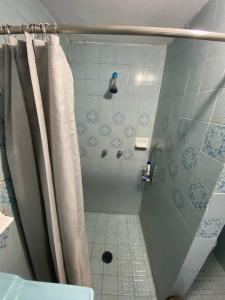 a shower with a shower curtain in a bathroom at Casa empresarial 5 minutos de puente internacional in Reynosa