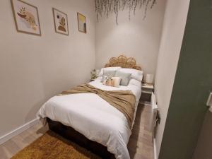 a bedroom with a bed with white sheets and pillows at Liverpool Gem: Cozy Studio Retreat in Liverpool
