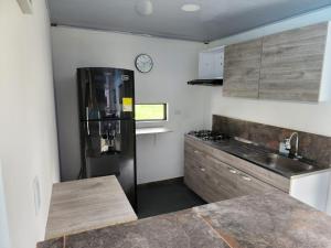 una cucina con frigorifero nero e bancone di Encanto Llanero XKPDestinations. a Villavicencio