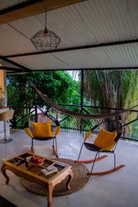 eine Veranda mit 2 Stühlen und einem Couchtisch in der Unterkunft Extraordinario chalet a 1h de Bta in San Antonio del Tequendama