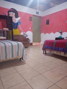 a room with two beds and a painting on the wall at Casa Zope in Panajachel