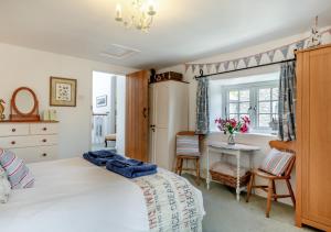 een slaapkamer met een bed, een tafel en een raam bij Olive Tree Cottage in Portesham