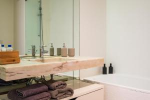 a bathroom with a sink and a mirror and towels at Apartment in Santos in Lisbon