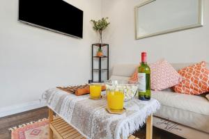 ein Wohnzimmer mit einem Tisch und 2 Gläsern Orangensaft in der Unterkunft Spacious 2 Bed Ensuite - Workspace, high-speed Wi-Fi in London