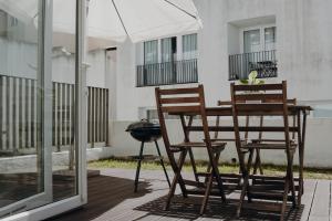 2 sillas y una mesa con sombrilla en el patio en Apartment in Santos en Lisboa