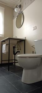 een badkamer met een wastafel, een toilet en een spiegel bij Casa de arriba in Rinlo