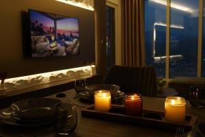 a dining room table with candles and plates and a table with a view at Stellarlux Apartment, 35th floor in Skopje