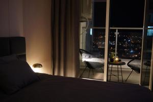 a bedroom with a bed and a view of a balcony at Stellarlux Apartment, 35th floor in Skopje +28 photos