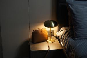a lamp on a table next to a bed at Stellarlux Apartment, 35th floor in Skopje +18 photos