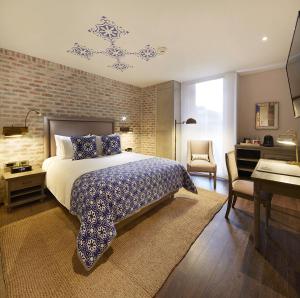 波哥大的住宿－阿提紳DC酒店- 傲途格精選酒店，一间卧室配有一张大床、一张桌子和一张书桌
