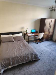 een slaapkamer met een bed en een bureau met een computer bij Double room near City Centre in Manchester