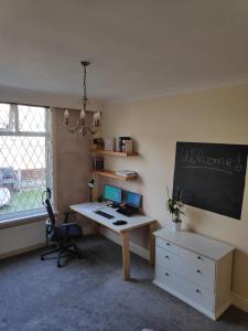 an office with a desk with a computer and a chalkboard at Double room near City Centre in Manchester