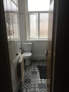 a bathroom with a toilet and a window at Double room near City Centre in Manchester