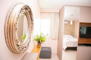 a bedroom with a mirror on the wall at Flat Tropical Caribessa in João Pessoa