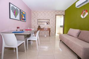 a living room with a couch and a table at Flat Tropical Caribessa in João Pessoa
