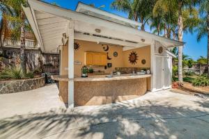 an outdoor kitchen with a large island in a backyard at Oasis with heated pool, mini golf, hot tub & barbq area in Oceanside