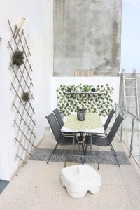 een tafel en stoelen op een balkon met een tafel en een tafel bij Espaço Jandira in Fajã de Baixo