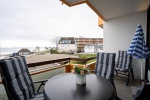 ein Tisch und Stühle auf einem Balkon mit Blick auf das Meer in der Unterkunft Berliner Hof - HOF/210 in Scharbeutz