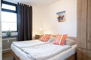 ein Schlafzimmer mit zwei Betten und einem Fenster in der Unterkunft Berliner Hof - HOF/210 in Scharbeutz