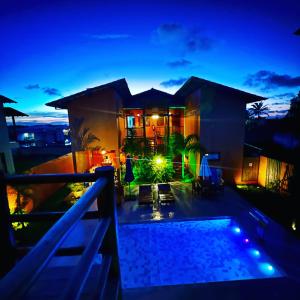 una casa con piscina por la noche en Pousada Vila dos Corais - Taipu de Fora, en Maraú