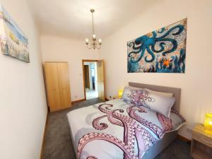 Un dormitorio con una cama con un pulpo pintado. en The Octopus - at Largs Town Centre with Private Parking, en Largs