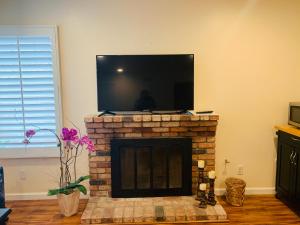 a living room with a fireplace with a flat screen tv at Oasis with heated pool, mini golf, hot tub & barbq area in Oceanside