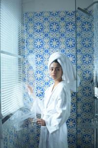 Una mujer parada en un baño con una toalla en The Artisan D.C. Hotel, Autograph Collection, en Bogotá