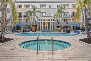 a pool in front of a building with palm trees at Luxury 2BDR with Parking & Pool - Marina del Rey in Los Angeles