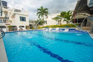 una grande piscina con acqua blu di fronte a un edificio di Hotel villeta suite a Villeta