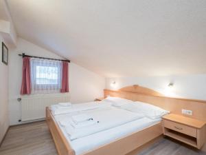 een slaapkamer met een groot wit bed en een raam bij Vanessa in Zell am See