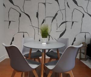 a table and chairs in a room with a tree mural at Urban Oasis Your Perfect Getaway in the Heart of Downtown! in Houston