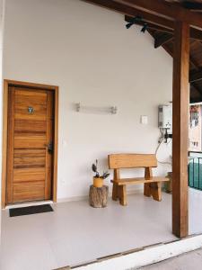 a room with a wooden door and a bench at Apart Avenida Monte Verde in Monte Verde