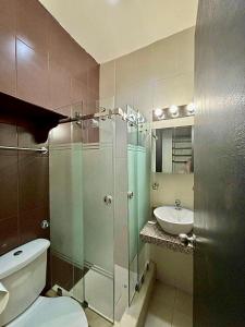 een badkamer met een douche, een toilet en een wastafel bij C&E Departamento , a una calle de la PLAYA & MALECÓN in Salinas