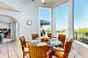 uma sala de jantar com mesa, cadeiras e janelas em Lake Bluff Retreat em Canyon Lake