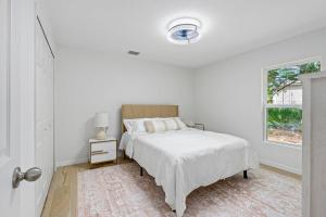 a white bedroom with a bed and a window at spacious 4-bedroom WITH KING BED in Palm Coast