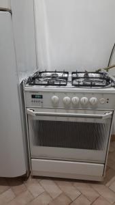a gas stove in a kitchen next to a refrigerator at Şirinevler Guest house in Istanbul